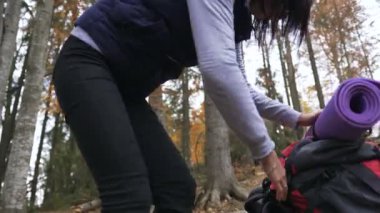Yakın çekim. Kişi yürüyüş - sırt çantası ile kadın uzun yürüyüşe çıkan kimse oturur ormandaki güzel orman, sonbahar turizm kavramı zam sırasında dinlenme