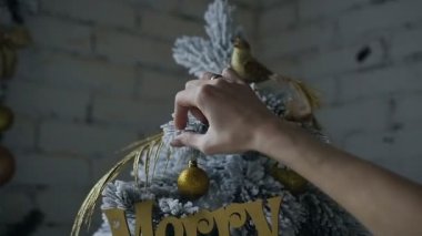 Altın süslemeli dekoratif bir Noel ağacı süsle bir kadının el bir close-up