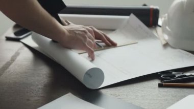 Yakın çekim mimar yeni bir proje üzerinde çalışıyor. Adam - ofis masasında büyük kağıda bir kalem ile bir plan, grafik, tasarım, geometrik şekiller mimar boyar