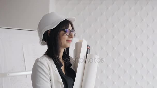 Uma trabalhadora de construção feminina usando capacete branco e segurando plantas isoladas — Vídeo de Stock