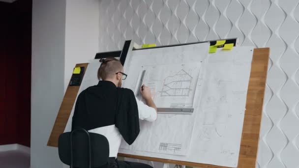 Jeune architecte masculin travaillant sur le dispositif de dessin un projet de plan de nouveau bâtiment résidentiel. Concept de travail sur les dessins techniques — Video