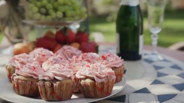 Yakın çekim. Tatlı kek çilek, üzüm ve mandalina masada pembe yuvarlak. Mutlu düğün kavramı. Parti tatlılar, martini asti