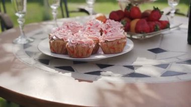 Yakın çekim. Tatlı kek çilek, üzüm ve mandalina masada pembe yuvarlak. Mutlu düğün kavramı. Parti tatlılar