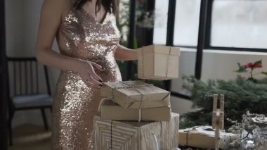 Hamile bir kadın kutuları hangi paketlenmiş hediyeler aile için yeni yıl için de sağlar. Gebelik anlayışı. Yeni yıl. Noel tatili. Hediyeler