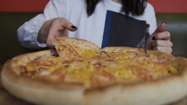 Close-up Sliced pizza wordt geserveerd op een ronde houten plaat. Womens handen Neem een stukje smakelijke pizza — Stockvideo