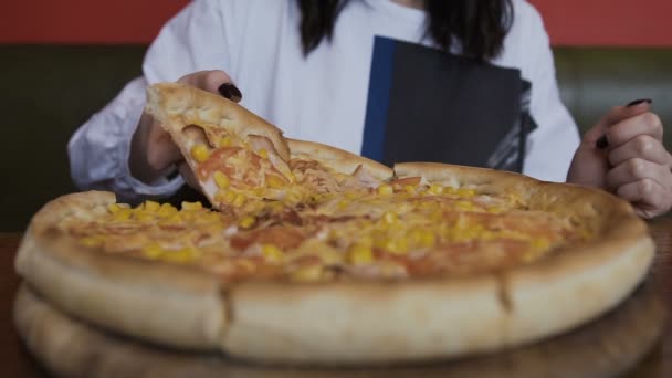 La pizza cortada en rodajas se sirve en un plato redondo de madera. Las manos de mujer toman un pedazo de pizza sabrosa — Vídeo de stock