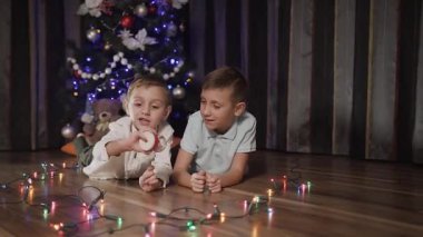 İki harika çocuk Noel ağacı yakınındaki katta odada yalan ve kar küresi ile oynarken iyi eğlenceler Noel Baba olan iç