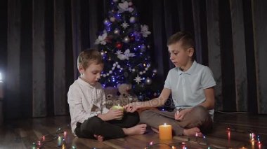 Noel ağacı ve aydınlatma dekoratif mumlar oda katta oturan iki küçük kardeş oteller