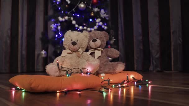 Fondo borroso de árbol de Navidad decorativo, guirnaldas y dos osos de peluche de juguete — Vídeo de stock