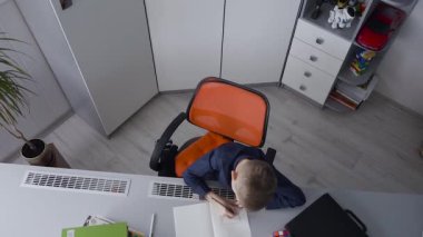 Onun dersleri İlköğretim okul çağındaki bir çocuk var. Çocuk ev ödevi ve bir resim çizim yaptı. Öğrenci öğrenme dersleri evde masada, okula geri.