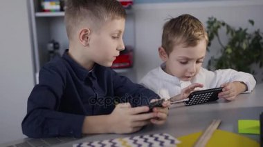 Güzel çocuklar evde telefonda oyun. Çocuk telefonda online bir oyun kazandı ve sevinçle elini yukarı ve dedi ki Evet kaldırdı