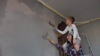 Kardeş kardeşi ile gri renk rulo kendi odasında duvar duvar kağıtları çizin. Evde tamir