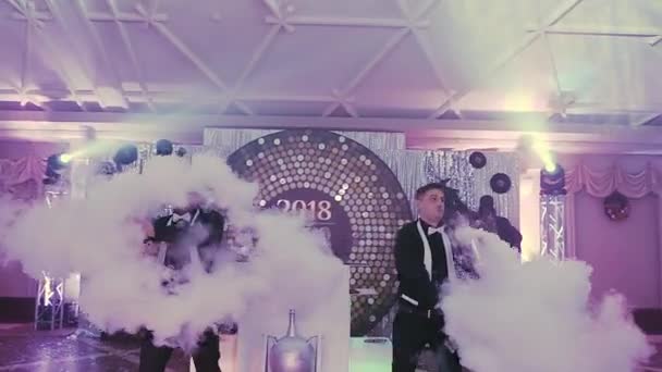 Twee jonge professionele bartenders jongleren op een disco feestje met glazen alcoholische cocktails en droogijs kubussen. Cool partij, barman weergeven — Stockvideo
