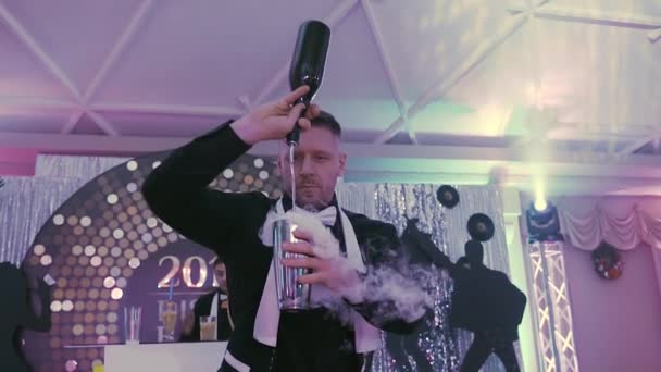 Close up. A professional bartender pours a cocktail with the effect of dry ice. Barman making delicious alcoholic cocktail on the disco party in the restaurant — Stock Video