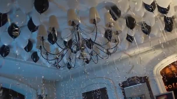 Decorated the ceiling of the restaurant with inflatable black and white balls around a large chandelier — Stock Video