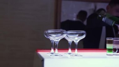 Genç, çekici barmen, barmen şaşırtıcı alkol kokteyl yapmak. Barmen onları yapım şaşırtıcı alkollü kokteyl dökme için bar boş cam gözlük koymak