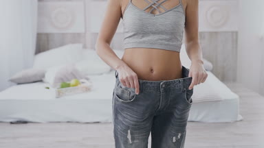 Genç kadın onu kilo kaybı ve eski kotunu evde ışık yatak odasında giyen gösterir. O sağlıklı yemek yeme başladı nasıl o kilo gösteren çok büyük kot pantolon bir ince kız