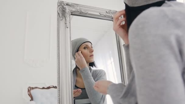 Een hipster vrouw ziet er in de grote spiegel en maakt een make-up. — Stockvideo