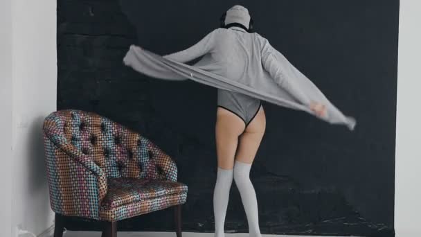 Vue de l'arrière-danseuse. La fille danse devant le mur noir près de la chaise colorée — Video