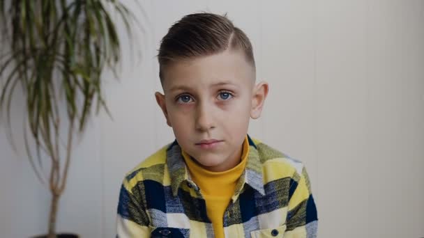 Χαριτωμένος έφηβος αγόρι με τα μπλε μάτια είναι ένα κλείσιμο του ματιού στην κάμερα και χαμόγελο. Καυκάσιος αγοράκι αναβοσβήνει τα μάτια του, απομονωμένα σε λευκό φόντο — Αρχείο Βίντεο