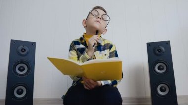 Ders kitabı gözlüklü sarışın çocuğu evde katta oturur ve defter orada ilginç bir şey kaydeder. Öğrenci okul evde yaparken istendi iş yok