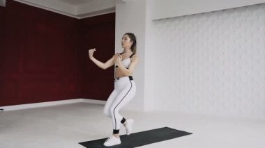 Fitness onun sabah dürtmek önce ısınma kadar güzel bir kız. Atletik kız atlar eğitim salonunda önce ısınma için gerçekleştirir. Kız beyaz spor giyim