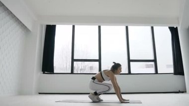 Sabah spor, egzersiz eğitim sırasında büyük windows yakınındaki spor salonunda genç fitness sarışın kadın çalışmaları. Beyaz spor giyindi