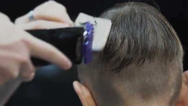 Närbild. Manliga frisyr med rakapparat. Professionell frisör gör en ny frisyr på vått hår med hjälp av åsen och rakapparat. Män barbershop — Stockvideo