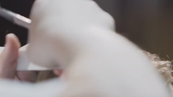 Detailní záběr rukou kadeřníka, který zastřihne vlasy chlapce v kadeřnický salon. Holič stříhání vlasů nůžky a hřeben vlasů — Stock video