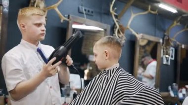 Kuaför Saç Kuaför Salonu küçük çocukta kurur. Küçük güzel çocuk saç kesimi tarafından Kuaför Berber Dükkanı, sandalyede otururken Başlarken