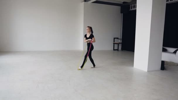 Raça mista. Saltar o treinamento de meninas na escola de ginástica é uma aptidão saudável. Menina adolescente saudável pulando com uma corda de salto. Exercício desportivo, alongamento, flexibilidade, aeróbica — Vídeo de Stock