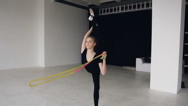 École de gymnastique et d'énergie. Gymnaste fille en tenue de sport noire avec corde en fente. Flexibilité en acrobatie et santé physique. Entraînement de fille sur école de gymnastique sur fond blanc. Sport et — Video
