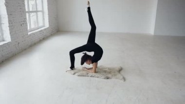 Yoga, meditasyon - jimnastik kız olun büyük pencereler yakınındaki beyaz arka plan okulda spor eğitim egzersiz. Esneklik eğitim egzersiz. Genç genç kız bir spor salonunda germe ısınma yerleştirmek. Kız