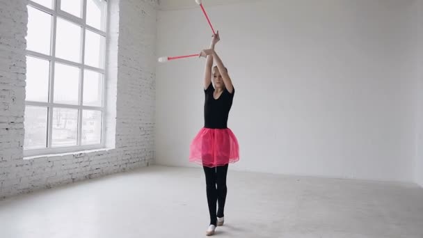 Desporto e sucesso. Mulher ginasta em sportssbody preto e saia rosa com maces rosa maces treino na escola de esporte. Escola de ginástica e energia. Exercício de menina no fundo branco — Vídeo de Stock