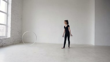 Kız bir jimnastik çember trenlerle. Ritmik Jimnastik: sarışın kız ile bir çember beyaz arka plan okulda jimnastik, jimnastik egzersiz eğitimi