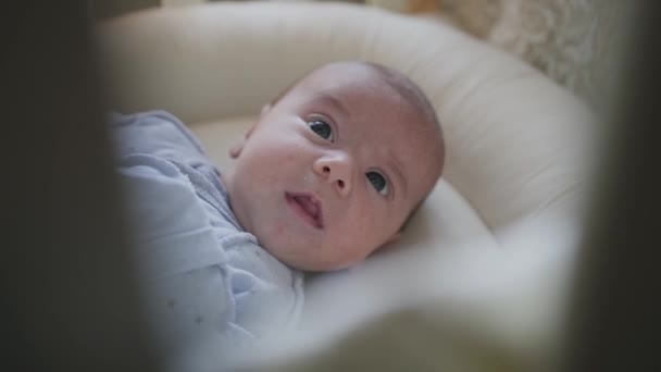 Porträt eines Neugeborenen, das in einem Kinderbett in einem Schlafzimmer liegt. Junge. schöner kleiner Junge — Stockvideo