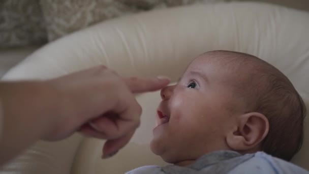 Close up. Mother touches little sons nose who lying in his crib. Charming baby smile. Baby boy — Stock Video
