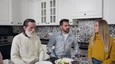 Mutlu, neşeli bir aile, yaşlı sakallı büyükbabası, festival masasında oturmuş, aile yemeğinden önce mutfakta dua ediyor.