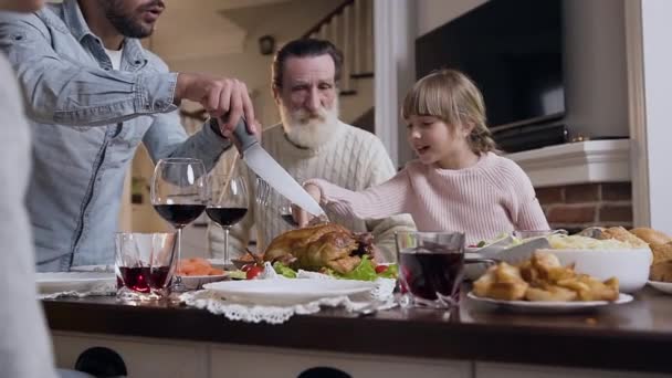 Όμορφο κορίτσι δείχνει στον πατέρα της ποιο μέρος της γαλοπούλας θέλει να φάει κατά τη διάρκεια του εορτασμού της ημέρας των Ευχαριστιών — Αρχείο Βίντεο