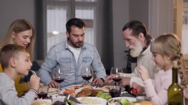 Çekici, mutlu, farklı nesil bir aile ziyafetin tadını çıkarıyor.