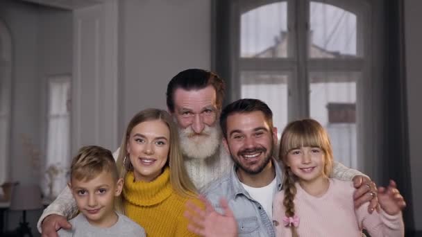 Schöne charmante Familie mit netten Lächeln posiert vor der Kamera und winkt mit den Händen — Stockvideo
