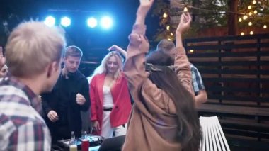 Neşeli arkadaşlarla birlikte bahçe evinin önünde parti veriyorlar. Yaz geceleri DJ 'lik yaparak dans ediyorlar.
