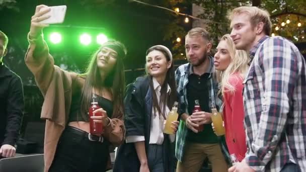 Группа друзей-женщин и мужчин празднуют праздник и делают селфи фото на мобильниках — стоковое видео