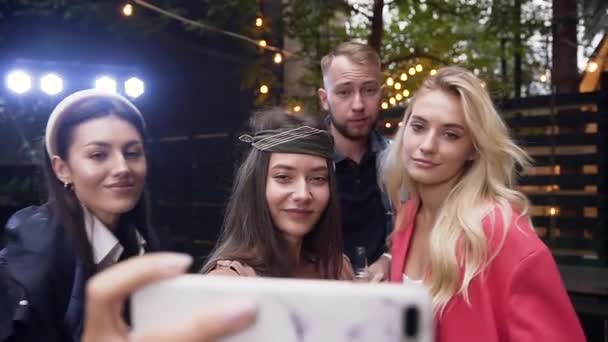 Radostní bělošští přátelé si užívají párty, pózují a dělají srandovní selfie. Mladí lidé se baví v noci večer v létě — Stock video