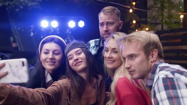 Fröhliche kaukasische Freunde genießen Dachterrassenparty, posieren und machen lustige Selfies. Junge Studenten haben Spaß bei der nächtlichen Disco-Party im Sommer — Stockvideo