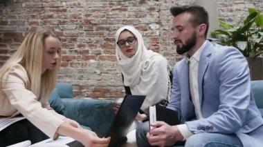 Modern ofisteki finansal projeleri altında çalışan farklı etnik kökenden genç ve yakışıklı insanlar.