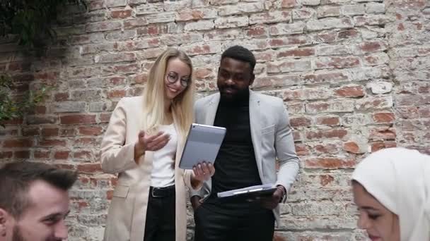 Sorrindo jovens colegas de negócios bem sucedidos satisfeitos com os resultados de seu trabalho conjunto no âmbito do projeto de negócios no escritório moderno — Vídeo de Stock