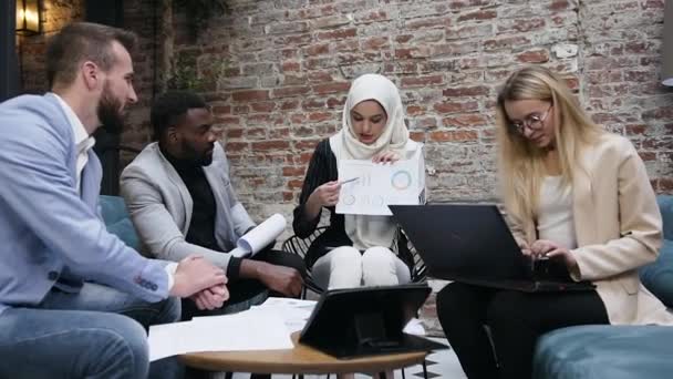 Belle femme d'affaires musulmane dans le hijab expliquant à ses collègues d'affaires multiraciales le graphique du rapport statistique — Video