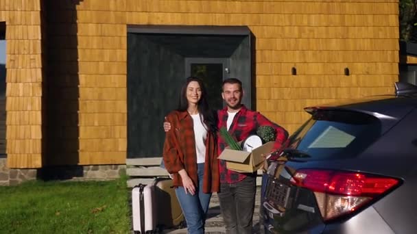 Front view of cheerful good-looking 35s man and woman which posing on camera with cute smiles during their moving to the new home — Stock Video