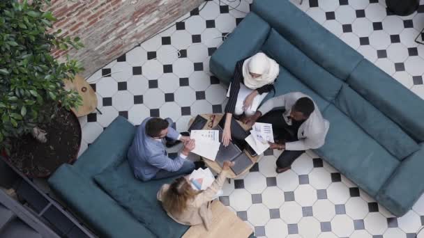 Des gens d'affaires prospères célèbrent le succès d'un nouveau projet en mettant les paumes de la main au centre de l'enjeu au-dessus de la table de travail à la salle de bureau — Video